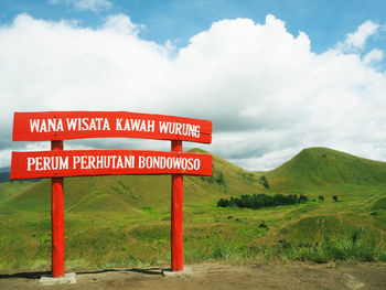 Information sign on landscape against sky