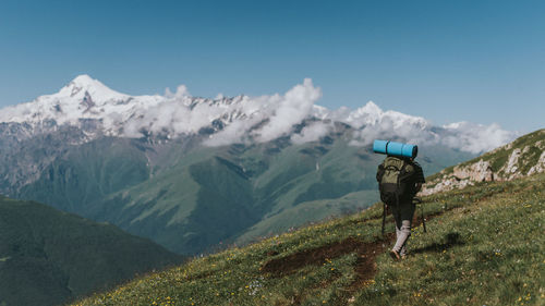 Rear view of man on mountain against sky