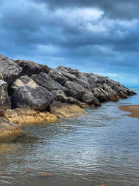 Rocks on beach against sky