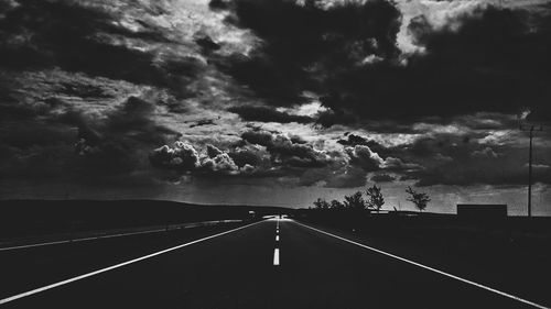 Road amidst trees against sky