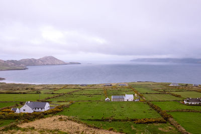 Scenic view of landscape by sea against sky