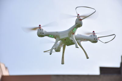 Low angle view of drone flying against clear sky