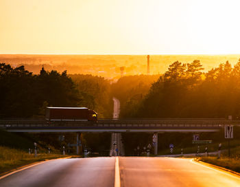 Road by bridge against sky during sunset