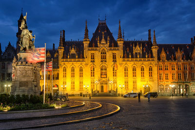 Famous tourist destination grote markt square and provincial court building in night bruges, belgium