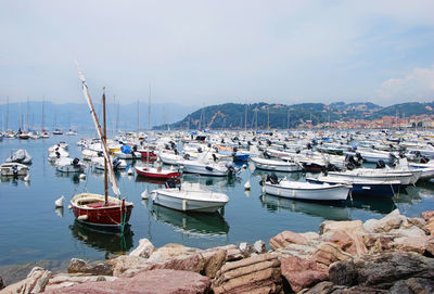 Boats moored at harbor against sky