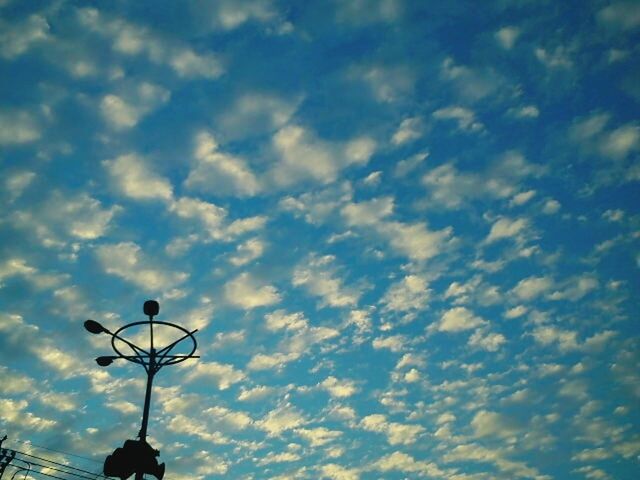 LOW ANGLE VIEW OF STREET LIGHTS AGAINST CLOUDY SKY