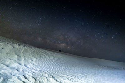 Scenic view of snowcapped mountains against sky at night