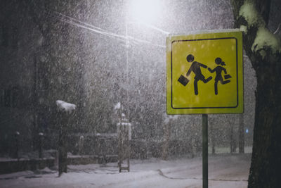 Road sign on wet street during winter