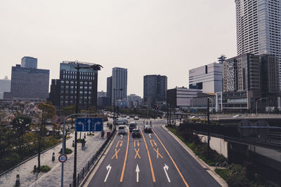 View of city street and buildings against clear sky