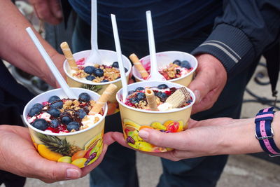 Closeup of ice cream with fruit. hands holding ice cream in paper cup