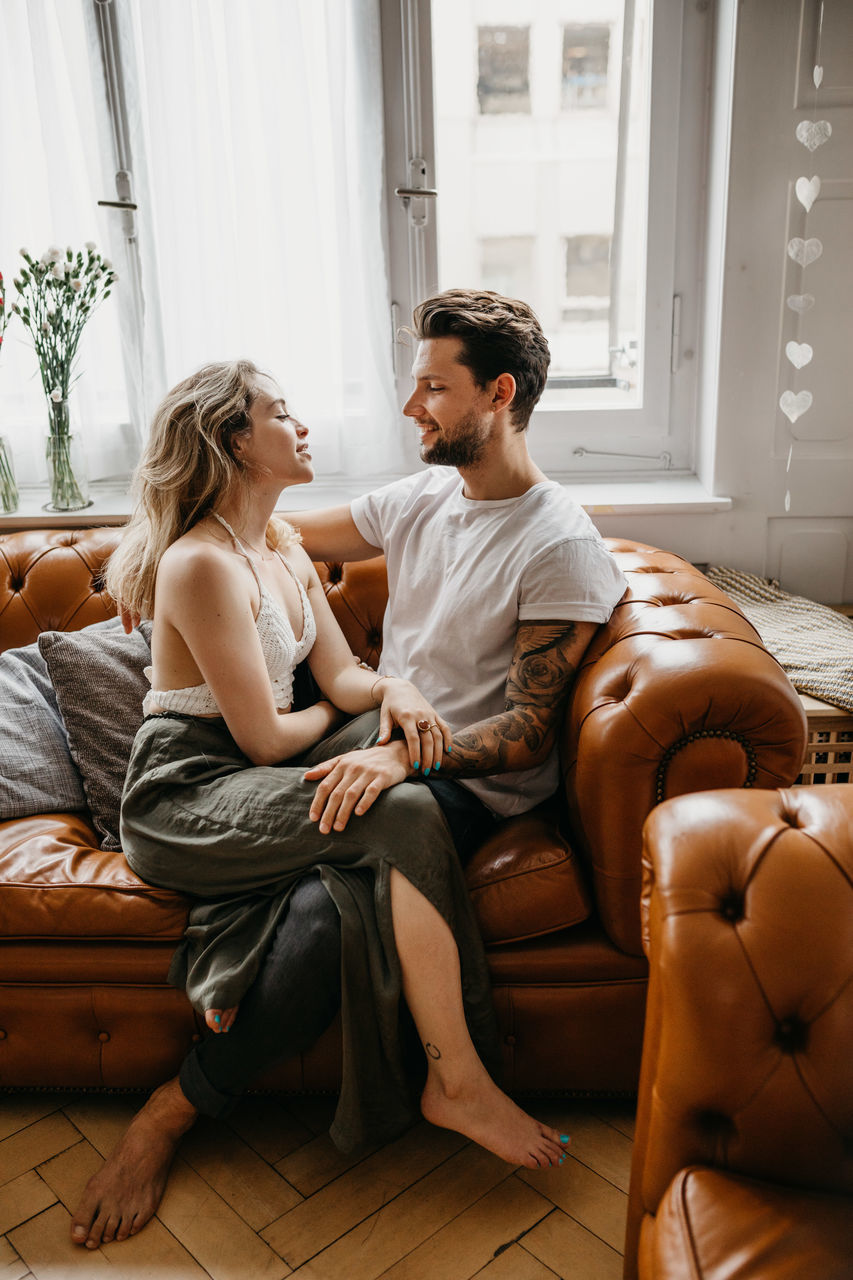 YOUNG COUPLE SITTING AT HOME