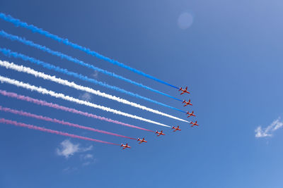 Low angle view of airshow against sky