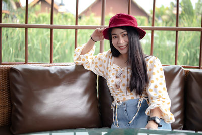 Portrait of beautiful young woman sitting in window