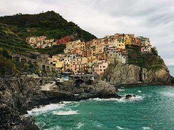 Scenic view of sea by townscape against sky