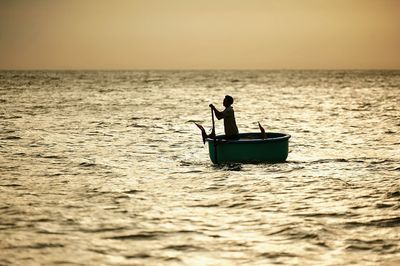 Boat sailing in sea at sunset