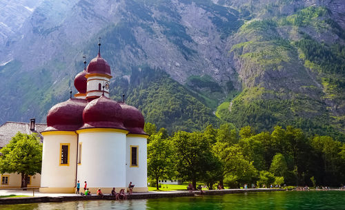 Traditional building by lake against mountain