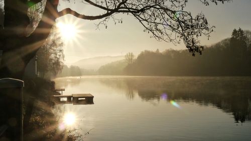 Scenic view of lake against bright sun