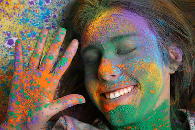 High angle view of young woman with face powder lying on floor