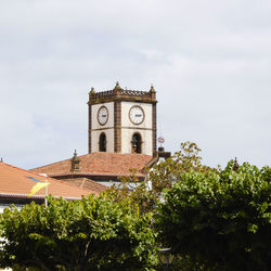 Low angle view of trees and building against sky