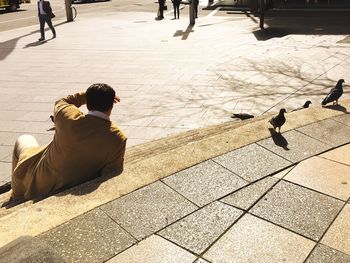 Rear view of woman sitting on floor