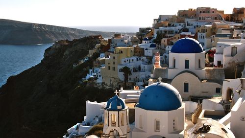 Buildings by sea at santorini on sunny day