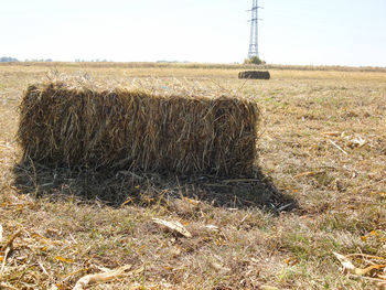 Hay bales on field against sky