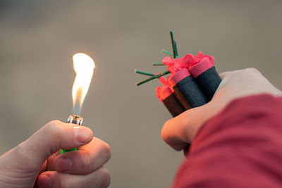 Close-up of person holding burning candle