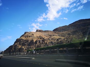 Road by mountain against blue sky
