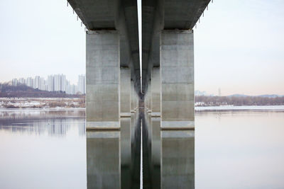 Bridge over river in city against sky