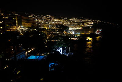 Illuminated cityscape against sky at night