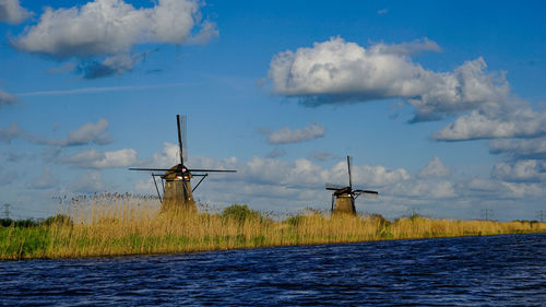 Traditional windmill on field against sky