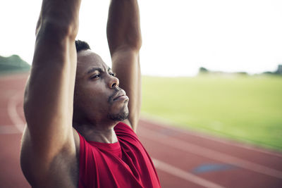 Close-up of determined male athlete exercising on running tracks