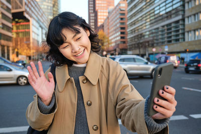 Young woman using mobile phone in city