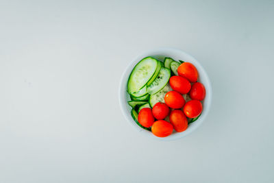 High angle view of tomatoes in bowl against white background