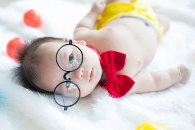 Close-up portrait of cute baby boy lying on bed