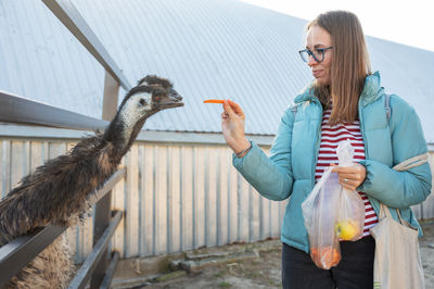 Side view of woman holding bird