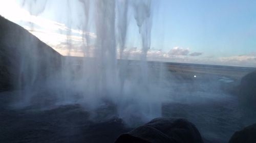 Scenic view of waterfall against sky