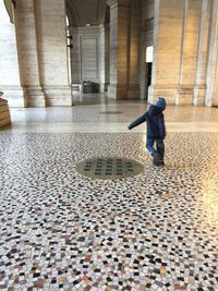 Full length of man standing on cobblestone