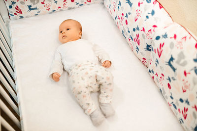 High angle view of cute baby boy sleeping on bed at home