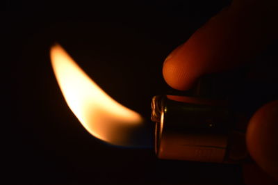 Close-up of lit candle over black background