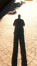 High angle view of silhouette man standing on floor