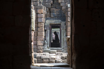 Statue seen through window of old building