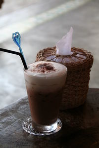 Close up vintage cup of coffee with milk froth on wood table