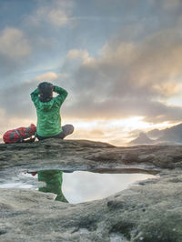 Rear view of boy on sea shore against sky
