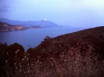 Scenic view of sea and mountains against sky