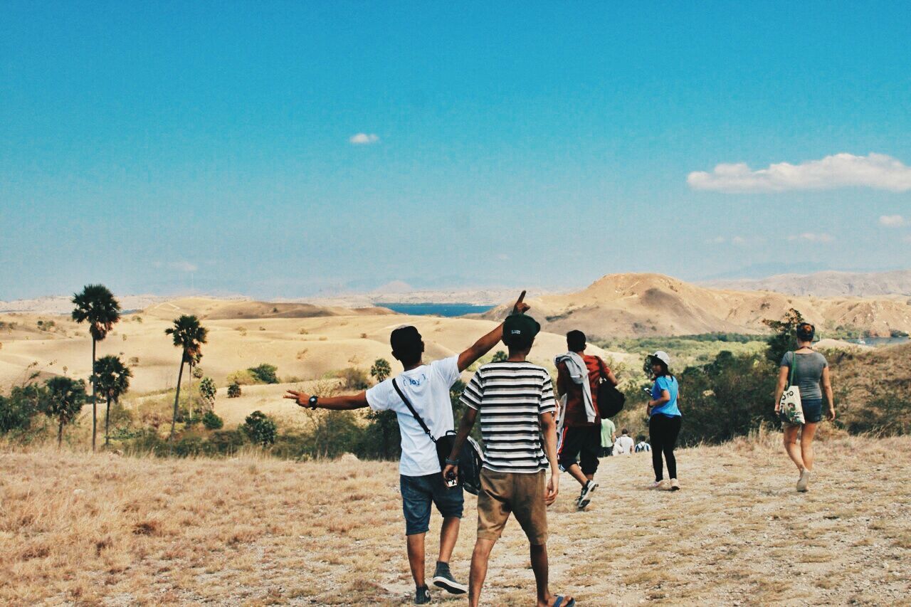 lifestyles, leisure activity, men, togetherness, full length, sky, person, rear view, landscape, casual clothing, sand, bonding, vacations, mountain, nature, walking, friendship, desert