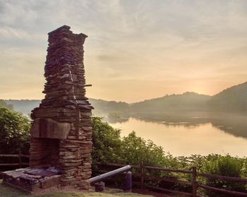 Stone structure against sky during sunset