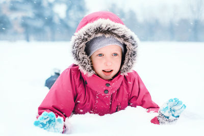 Close-up of girl playing on snow outdoors