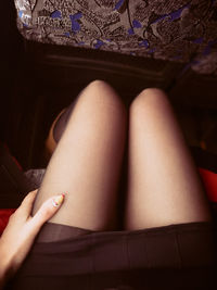 Midsection of young woman wearing stockings while sitting on seat