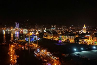 Illuminated cityscape against sky at night